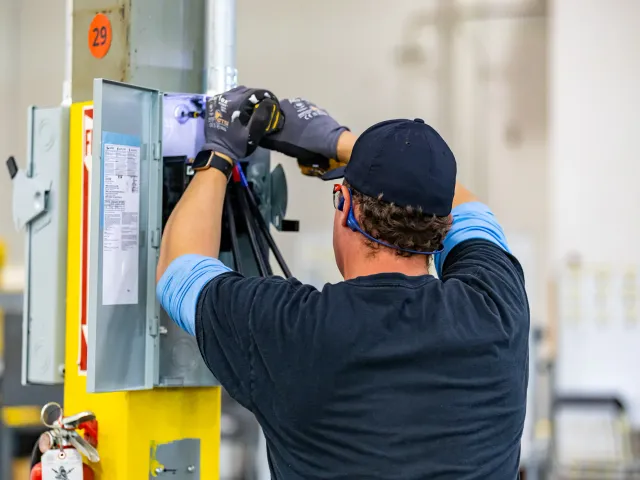 Electrician installing industrial disconnect switch