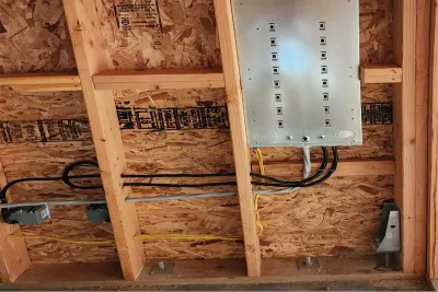 Phase 3 Electric electrician working on home remodel wiring during new construction framing