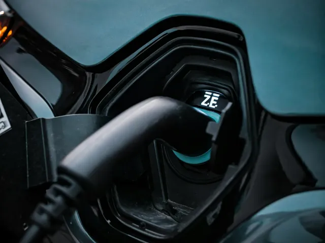 Electric vehicle plugged into a slow Level 1 charger in a residential garage