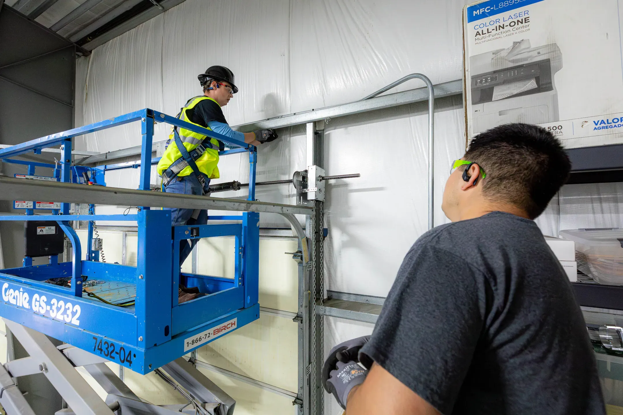 Industrial electrician installing conduit from a scissor lift