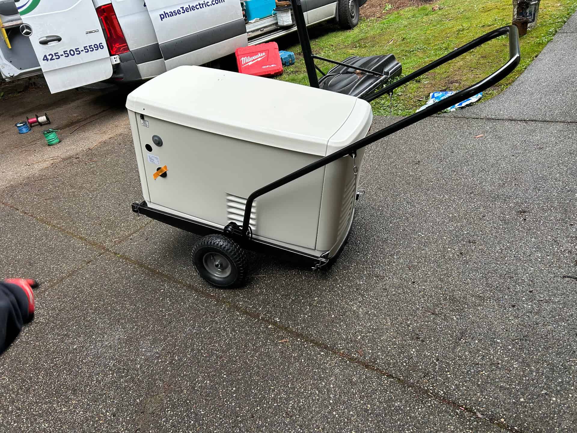 Portable generator on a wheeled cart outdoors.